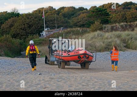 Horton Beach Gower Wales UK RNLI Inshore Lifeboat Rückkehr zur Lifeboat Station nach dem Training unterstützt von Beach Recovery Fahrzeug und Crew am Strand Stockfoto