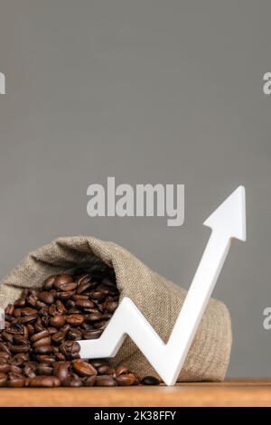 Eine Tüte Kaffeebohnen und ein Pfeil nach oben. Die Kosten für Kaffee auf den Märkten der Welt. Das Konzept des Wachstums der Kosten für Kaffee Stockfoto