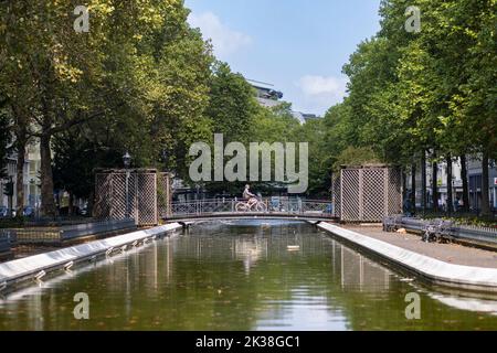 Ein Biker überquert eine Brücke im öffentlichen Park in Köln Stockfoto