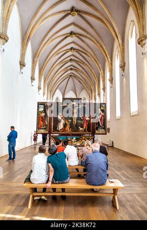 Besucher sehen den Isenheimer Altar von Matthias Grünewald in der Kapelle des Unterlinden Museums, Colmar, Frankreich Stockfoto