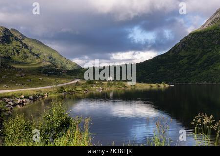 Wunderschöne Landschaften in Norwegen. Nordland. Wunderschöne Landschaft eines weißen Hauses in einem Tal auf den Lofoten-Inseln. Sommersonntag. Selektiver Fokus. Stockfoto