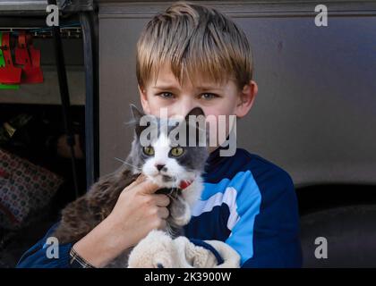 Schewchenkowe, Ukraine. 21. September 2022. Ein kleiner Junge aus Kupiansk trägt seine Katze vor der Evakuierung mit sich. Ukrainische Zivilisten werden evakuiert, da ukrainische und russische Streitkräfte im Nordosten des Landes unter schweren Kämpfen stehen. Die Ukraine hat auf Widerstand der russischen Truppen bei einer erfolgreichen Gegenoffensive im Nordosten des Landes gestoßen und fast die gesamte Region Charkow wieder erobert. (Bild: © Ashley Chan/SOPA Images via ZUMA Press Wire) Stockfoto