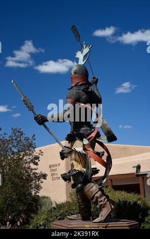 Eine Bronzestatue eines Apache Mountain Spirit Dancer vor dem Museum of Indian Arts and Culture in Santa Fe, New Mexico. Stockfoto