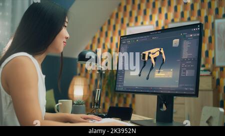 Asiatische Frau arbeitet am pc in 3D Modellierungsprogramm aus der Ferne aus dem Home Office und die Schaffung 3D Prototyp des modernen Roboters Stockfoto