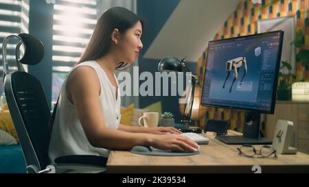Asiatische Frau arbeitet am pc in 3D Modellierungsprogramm aus der Ferne aus dem Home Office und die Schaffung 3D Prototyp des modernen Roboters Stockfoto