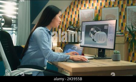 Asiatische Freiberuflerin, die vom Home Office aus arbeitet und 3D Prototypen eines modernen VR-Headsets in professioneller 3D-Modellierungssoftware mit pc und digitalem Tablet erstellt Stockfoto