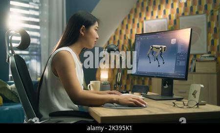 Asiatische Frau arbeitet am pc in 3D Modellierungsprogramm aus der Ferne aus dem Home Office und die Schaffung 3D Prototyp des modernen Roboters Stockfoto