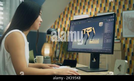 Asiatische Frau arbeitet am pc in 3D Modellierungsprogramm aus der Ferne aus dem Home Office und die Schaffung 3D Prototyp des modernen Roboters Stockfoto