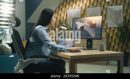 Weibliche asiatische 3D Designerin Erstellen 3D Modell der E-Gitarre und Herstellung von Grafik, mit Software für die Modellierung 3D Projekte während der Arbeit an pc und Tablet zu Hause. Stockfoto