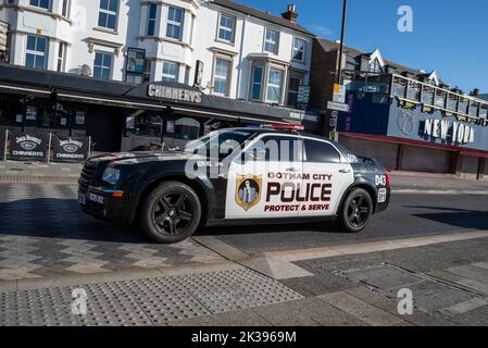 Das Polizeiauto von Gotham City markierte Chrysler 300 auf der Marine Parade in Southend on Sea, Essex, Großbritannien. „Protect & Serve“-Schriftzug. Vorbei an der New Yorker Arkade Stockfoto