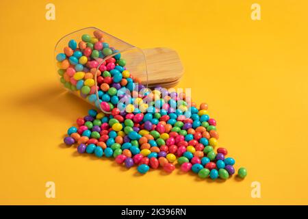 Verschiedene helle bunte Schokolade Süßigkeiten, Zucker beschichtete Schokolade Edelsteine Süßigkeiten. Schokoladenbonbon-Edelsteine auf buntem Hintergrund. Stockfoto