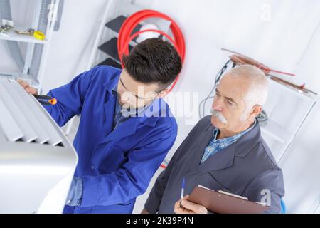 Der Wartungsmann und der Lehrer der Klimaanlage Stockfoto