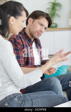 Verärgerte Frau, die ihren Mann anschrie, nachdem sie Rechnungen erhalten hatte Stockfoto