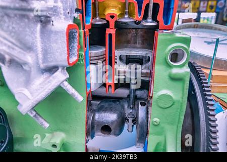 Der Verbrennungsmotor des Autos in der Sektion. Zylinder, Kolben und Zündkerzen. Mechaniker-Ausbildung und Fahrschulunterricht Stockfoto