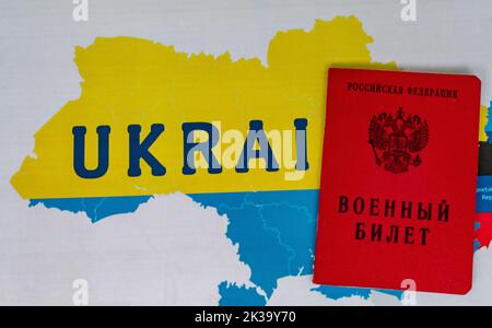 25. September 2022, Moskau, Russland. Militärticket eines Reservesoldaten der Russischen Föderation auf dem Hintergrund einer Karte der Ukraine Stockfoto