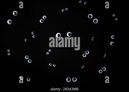 Lustiges Gesicht aus wackligen Augen auf schwarzem Hintergrund Stockfoto