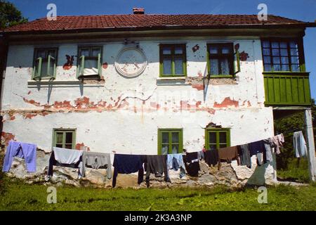 Roșia Montana, Kreis Alba, Rumänien, ca. 1999. Wäsche trocknen in der Sonne auf einer Wäscheleine außerhalb eines Hauses in einem schlechten Zustand, eines der historischen und architektonischen Denkmäler im Dorf. Stockfoto