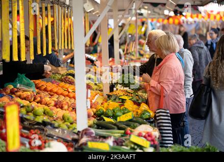 PRODUKTION - 21. September 2022, Hessen, Frankfurt/Main: Kunden an einem Obststand auf dem Wochenmarkt im Frankfurter Stadtteil Bornheim. Vor dem Hintergrund der steigenden Inflation beobachten zahlreiche Trader eine Veränderung des Kaufverhaltens ihrer Kunden. (To dpa: ''Wochen der Wahrheit kommen gerade': Unsicherheit an den Wochenmärkten') Foto: Boris Roessler/dpa Stockfoto