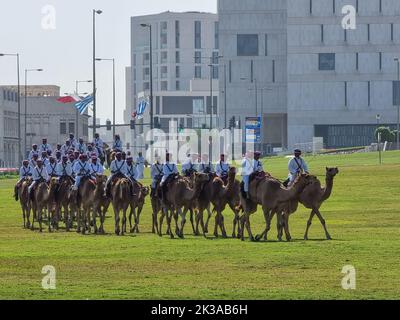 Polizei auf Kamel in traditioneller Kleidung in Doha, Katar. Doha hat eine einzigartige Polizeieinheit, die traditionelle arabische Kostüme trägt. Stockfoto