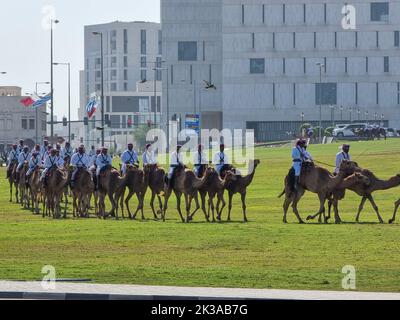 Polizei auf Kamel in traditioneller Kleidung in Doha, Katar. Doha hat eine einzigartige Polizeieinheit, die traditionelle arabische Kostüme trägt. Stockfoto