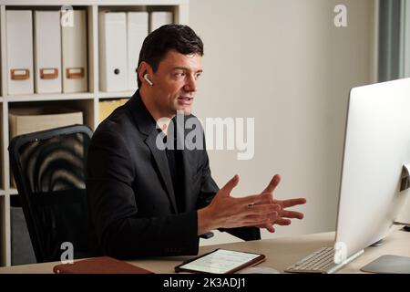 Unternehmer mit Online-Treffen mit Kollegen und Diskussion von Projektdetails Stockfoto