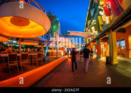 Blick auf die Straße auf den beleuchteten Clarke Quay im historischen Quay am Flussufer, berühmt für Nachtclubs und Nachtleben. Stockfoto