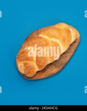 Osterbrot, griechisches Tsoureki, challah auf farbigem Hintergrund. Traditionelles Essen. Kreatives Fotokonzept. Draufsicht, Kopierbereich Stockfoto