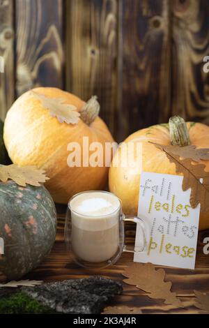 Herbstlicher Kaffee in einem Becher mit Kürbissen und Eichenblättern, auf dem Hintergrund der Phrase aus Strasssteinen Kürbis-Gewürzlakte. Hochwertige Fotos Stockfoto