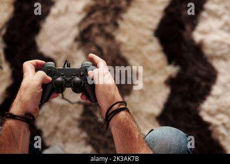 Hände eines reifen Mannes mit Controller, der Videospiel spielt Stockfoto