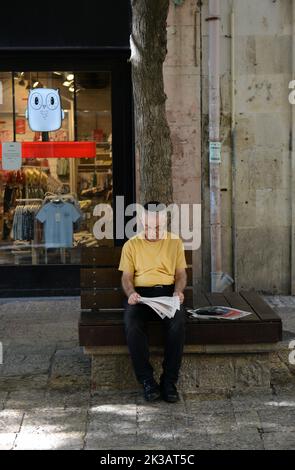 Ein Israeli liest die Morgenzeitung in Zentral-Jerusalem, Israel. Stockfoto