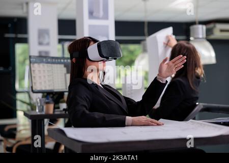 CAD-Designer in vr-Headset arbeitet an Projekt in Metaverse. Mitarbeiter Engineering im Architekturbüro, Architekt mit Virtual-Reality-Brille, Immobilienmakler Arbeiter in ar Brille Stockfoto