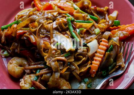 Betrunkene Nudeln, Pad kee mao, mit Garnelen, Basilikum, Chilli, Paprika und grüne Bohnen. Nahaufnahme auf einer Platte. Stockfoto