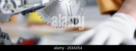 Handschuhen, die mit einer Kreissäge arbeiten, Nahaufnahme Stockfoto