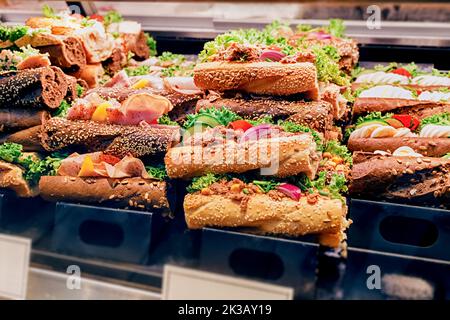 Eine Auswahl an Sandwiches mit verschiedenen Füllungen werden im Schaufenster eines Ladens oder Supermarkts verkauft. Snacks und Fast-Food-Konzept Stockfoto