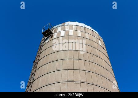 Nahaufnahme eines alten, runden Betonwandsilos mit Kuppeldach und blauem Himmel-Hintergrund, der die natürliche Verwitterung von Alters her zeigt Stockfoto