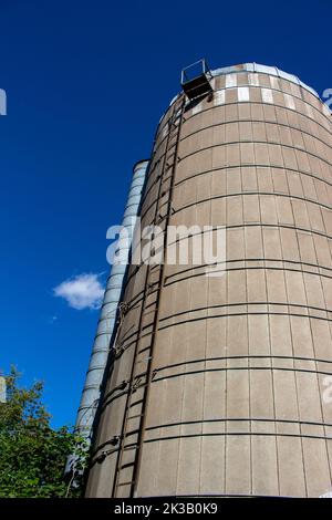 Nahaufnahme eines alten, runden Betonwandsilos mit Kuppeldach und blauem Himmel-Hintergrund, der die natürliche Verwitterung von Alters her zeigt Stockfoto