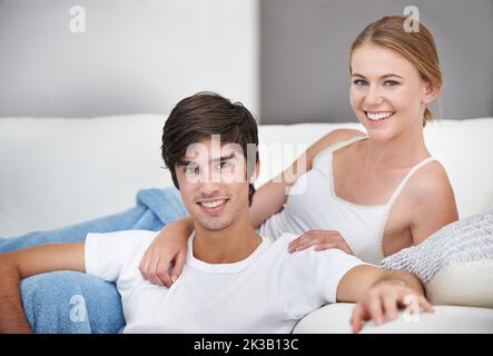 Ein junges Paar, das auf dem Sofa Fernsehen schaute. Stockfoto
