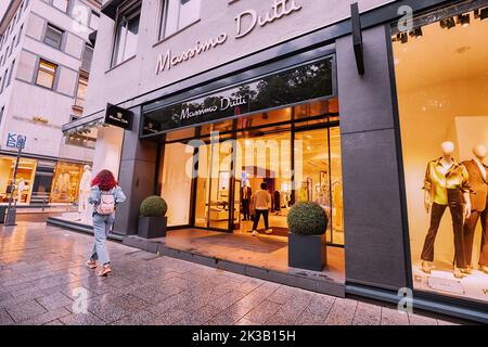 21. Juli 2022, Düsseldorf, Deutschland: Berühmter Modehaus der Kette Massimo Dutti Eingang mit Display. Menschen, die an der Vitrine vorbeikommen Stockfoto