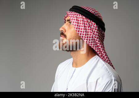 Porträt eines jungen arabischen Mannes auf grauem Hintergrund im Studio Stockfoto