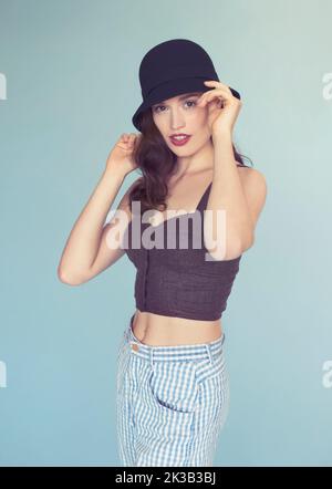 Shes hat ihren eigenen Stil. Studio-Porträt einer attraktiven und stilvollen jungen Frau mit einem altmodischen Hut. Stockfoto