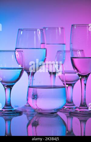Weingläser mit neonfarbenem Licht Stockfoto