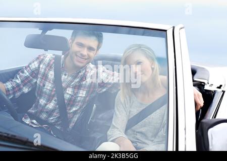 Waren weniger unterwegs... Ein glückliches Paar, das in einem Cabrio eine Autoreise gemacht hat. Stockfoto