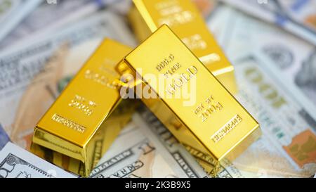 Goldbarren auf dem Hintergrund von US-Dollar-Banknoten Stockfoto