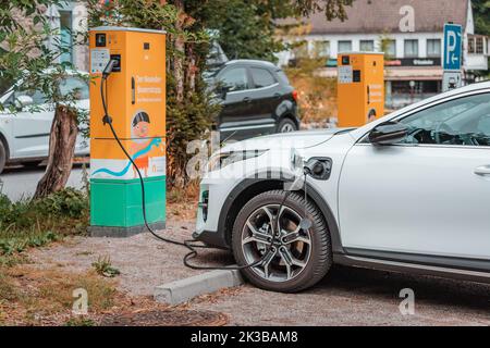 22. Juli 2022, Düsseldorf, Deutschland: Moderne KIA-Elektroautos werden auf dem Parkplatz des Neanderthal-Museums aufgeladen. Umweltbewusstsein und Green tran Stockfoto