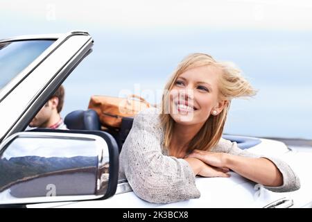 Ein junges Paar genießt eine Fahrt in einem Cabrio. Stockfoto