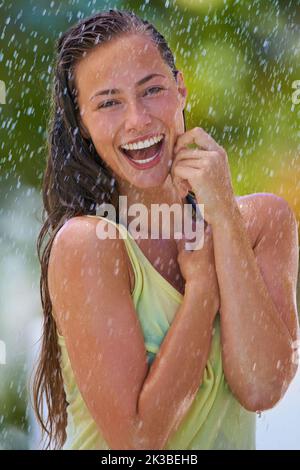 Frühlingsregen. Eine junge Frau, die den Regen genießt. Stockfoto