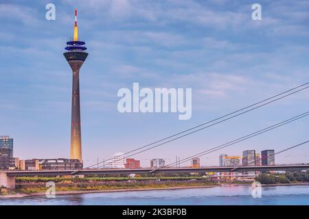 22. Juli 2022, Düsseldorf, Deutschland: Der Rheinturm ist ein berühmtes Reise- und Sightseeing-Wahrzeichen mit dem dunklen Wasser des Rheins im for Stockfoto