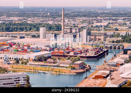 Ein Industriehafen mit Frachtcontainern und Fabrikrohren in den Vororten von Düsseldorf am Rheinufer Stockfoto