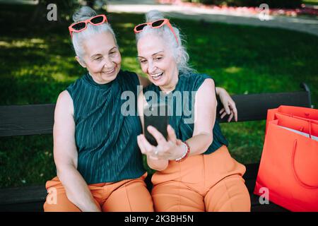 Ältere Frauen Zwillinge im Freien in der Stadt überprüfen Smartphone. Stockfoto