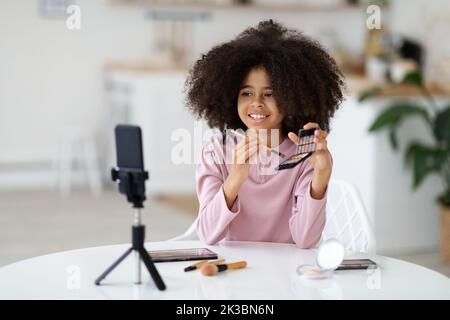 Präteen schwarzes Mädchen Aufnahme Video, mit Telefon Stockfoto